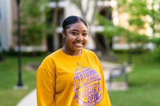 a female student on campus wearing a long-sleeved yellow shirt