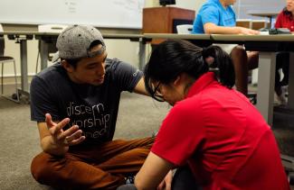 Campus minister praying for student in classroom