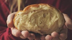 Person holding fresh loaf of bread