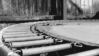 black and white image of the metal springs of a trampoline