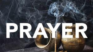 One urn turned on its side and one urn upright with stick of incense and the word "Prayer" across the image