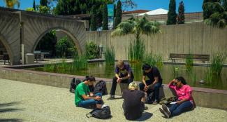 Students gathered in circle on campus, praying together