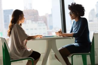 Two young women sitting at table in coffee shop