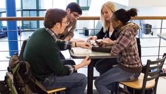 Group of diverse students gathered for Bible study in college student center