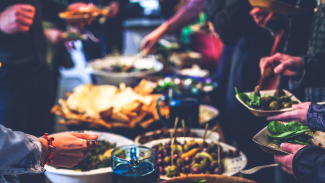 Closeup of large spread of food and people's plates