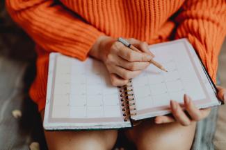 Woman writing in planner notebook