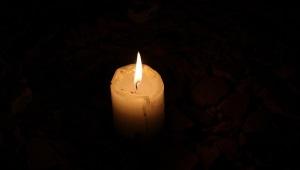 a small candle burning in darkness