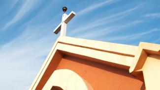 Closeup of church steeple rising up into blue sky