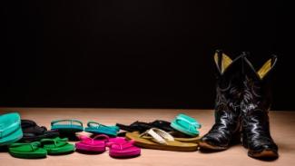 Pile of multicolored flip-flops and set of black cowboy boots