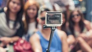 a person holding a selfie stick in front of their friends