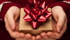 a cupped pair of hands holding a small box with a bow on it.