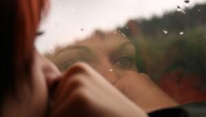 Closeup of woman looking out the window on a rainy day