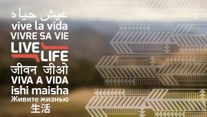 Live Life written in different languages on blurred landscape background
