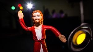 Jesus action figure standing in spotlight with dark background