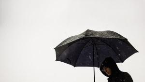 a person standing under an umbrella on a cloudy day