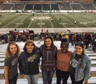 Kerrington standing with group of friends at football game