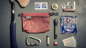 Bunch of survival gear including hatchet, carabiner, ice pack, and bandages 