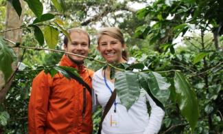 a couple smiling together in a wooded area