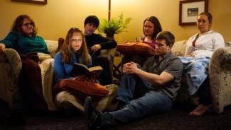 Group of students sitting on couch listening to Scripture being read