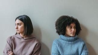 Two women next to each looking frustrated, refusing to make eye contact