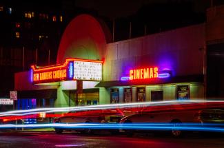 the neon signs of a movie theatre at night