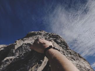 Closeup of a person's hand as she climbs mountain