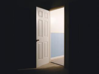 a well-lit open door surrounded by darkness