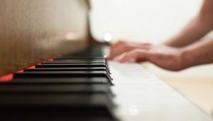 Closeup of person's hands on piano keys