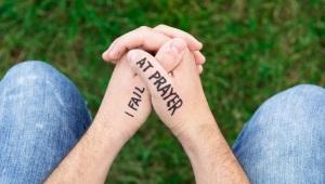 Person's hands folded for prayer with the words: "I Fail at Prayer" written on hands in marker.