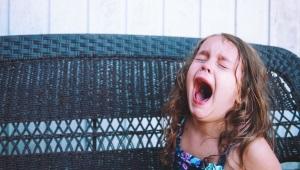 Young girl closing eyes, crying and yelling