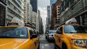 Yellow taxis on a crowded city street surrounded by skyscrapers