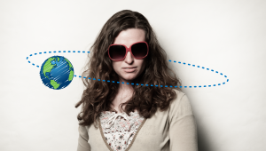 a woman with sunglasses and a small picture of Earth revolving around her head