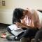 student sitting on floor, reading bible and taking notes