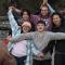 diverse group photo of people making a star shape with their arms and hands linked