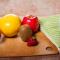 a wooden table with fruits, vegetables, and knife