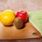 a wooden table with fruits, vegetables, and knife