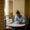 One student sitting at table reading Bible