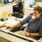 a man sitting in a cubicle blowing a bubble with gum