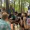 Calvin with group of fellow InterVarsity students seated at picnic table surrounded by trees