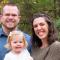 Photo of Ryan with wife and infant daughter standing in forest