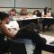 Group of students seated at tables writing letters to incoming freshmen