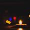 Closeup of candle with colorful lights in dark background