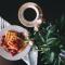 Plate of waffles with coffee on table next to plant