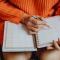 Woman writing in planner notebook