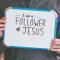 Man holding whiteboard that says "I am a Follower of Jesus"