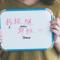 Woman holding whiteboard that says "I am a Follower of Jesus" in English and Chinese characters