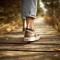 Feet wearing sneakers walking on a forest path.