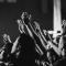 A black and white photo of many hands raised in worship