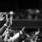 Black and white photo of many hands raised in worship