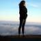 Woman standing on ridge overlooking mountains